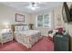 Cozy bedroom with a floral-patterned bedspread, a ceiling fan, and a window at 5235 Island Terrace Ct, Lady Lake, FL 32159