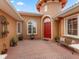 Welcoming front entrance featuring paver patio, red door, manicured landscape, and charming bench at 5235 Island Terrace Ct, Lady Lake, FL 32159