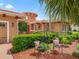 Home exterior with red door, manicured hedges, decorative chairs, and mulch landscaping at 5235 Island Terrace Ct, Lady Lake, FL 32159