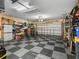 Organized two-car garage featuring storage solutions and a checkered floor at 5235 Island Terrace Ct, Lady Lake, FL 32159