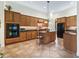 Kitchen with an island, tiled floors, custom wood cabinets, granite countertops, and modern appliances at 5235 Island Terrace Ct, Lady Lake, FL 32159