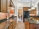 Well-equipped kitchen featuring wooden cabinets, granite counters, tile backsplash, and modern appliances at 5235 Island Terrace Ct, Lady Lake, FL 32159