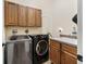 Well-equipped laundry room with modern washer and dryer units and storage cabinets at 5235 Island Terrace Ct, Lady Lake, FL 32159