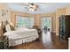 Large bedroom with hardwood floors, back patio access, and a ceiling fan at 5235 Island Terrace Ct, Lady Lake, FL 32159