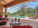 Beautiful screened pool area with comfortable outdoor seating and lush landscaping at 5235 Island Terrace Ct, Lady Lake, FL 32159