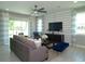 Bright living room featuring a ceiling fan, plush gray sofa, and an entertainment center at 5390 Marshelder St, Apopka, FL 32712