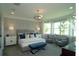 Serene bedroom featuring a large bed, sitting area, and bay window with lots of natural light at 5390 Marshelder St, Apopka, FL 32712