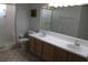 Bathroom featuring double sinks, neutral tile, an enclosed shower with bench, and bright lighting at 5436 Astor St, Leesburg, FL 34748