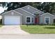 Charming single Gathering home featuring a well-manicured lawn, brick driveway, and a vibrant red front door at 5436 Astor St, Leesburg, FL 34748