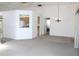 Bright living room with neutral carpet, chandelier, and a cutout view of the kitchen at 5436 Astor St, Leesburg, FL 34748