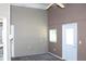 Neutral-toned living room with a small window, tiled floor, and back door leading to the exterior at 5436 Astor St, Leesburg, FL 34748