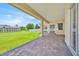 Covered patio with brick pavers overlooking a well-maintained backyard and lawn at 5556 Vintage View Blvd, Lakeland, FL 33812