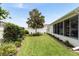 Green backyard with a mature magnolia tree, lush landscaping, and a white fence, offering a peaceful and private outdoor space at 579 Audrey Ln, The Villages, FL 32162