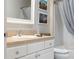 Close-up of bathroom vanity with framed mirror and shower/tub combination at 579 Audrey Ln, The Villages, FL 32162