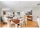 Light-filled dining room boasts wood floors, a chandelier, and a view into the open living space at 579 Audrey Ln, The Villages, FL 32162
