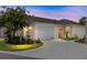 Charming home featuring a well-manicured lawn, attached garage, and inviting curb appeal at dusk at 579 Audrey Ln, The Villages, FL 32162