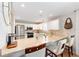 Open kitchen with breakfast bar, white cabinetry, stainless appliances, and recessed lighting at 579 Audrey Ln, The Villages, FL 32162