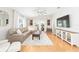 Bright living room features neutral decor, hardwood floors, and a large sectional sofa at 579 Audrey Ln, The Villages, FL 32162