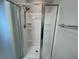 Bathroom with white shower, glass doors and stainless steel shower head at 579 Audrey Ln, The Villages, FL 32162