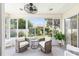 Bright sunroom featuring large windows, neutral decor, fan, and comfortable seating, perfect for relaxation and enjoying the view at 579 Audrey Ln, The Villages, FL 32162