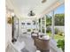 Inviting sunroom showcasing neutral furniture, a ceiling fan, and views of the landscaped backyard, creating a cozy retreat at 579 Audrey Ln, The Villages, FL 32162