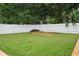Grassy backyard with privacy fence and paved area with firepit or planting area at 721 Mendoza Dr, Orlando, FL 32825