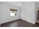Bedroom featuring dark floors, white walls and trim, a window, and a double-door closet at 721 Mendoza Dr, Orlando, FL 32825
