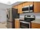 Well-equipped kitchen featuring stainless steel appliances, wood cabinets, and stylish countertops at 721 Mendoza Dr, Orlando, FL 32825