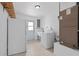 Well-lit laundry room with washer, utility sink, fridge and white tile flooring at 721 Mendoza Dr, Orlando, FL 32825