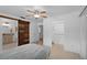 Bedroom featuring a decorative sliding barn door, neutral tile, closet and ensuite access at 721 Mendoza Dr, Orlando, FL 32825