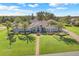 Expansive lawn and mature trees enhance this beautiful single-story home with lush landscaping at 7350 Spring Mountain Ln, Yalaha, FL 34797