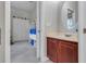 This bathroom features a wooden vanity with a sink and an oval mirror at 7350 Spring Mountain Ln, Yalaha, FL 34797