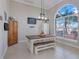 Bright dining area with large windows and a rustic dining table with bench seating at 7350 Spring Mountain Ln, Yalaha, FL 34797