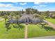 Beautiful single-story home with manicured lawn and walkway, palm trees, and inviting entrance at 7350 Spring Mountain Ln, Yalaha, FL 34797