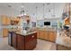 Spacious open kitchen featuring granite countertops, an island, and maple cabinetry at 7350 Spring Mountain Ln, Yalaha, FL 34797