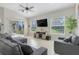 Bright living room featuring neutral tones, comfortable seating, and large windows offering natural light at 7350 Spring Mountain Ln, Yalaha, FL 34797