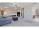 Spacious living room features comfortable sofa, TV, and neutral carpet at 7350 Spring Mountain Ln, Yalaha, FL 34797