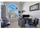 Home office with a large arched window, a desk with multiple monitors, and comfortable seating at 7350 Spring Mountain Ln, Yalaha, FL 34797