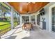 Inviting screened patio with wood ceilings, outdoor dining set, and views of the landscaped backyard at 7350 Spring Mountain Ln, Yalaha, FL 34797