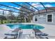 Inviting screened-in pool with sun loungers, spa and sparkling water for ultimate outdoor relaxation and enjoyment at 7350 Spring Mountain Ln, Yalaha, FL 34797