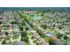 An aerial view of a lush community with single Gathering homes next to a verdant green golf course at 8377 Se 177Th Bartram Loop, The Villages, FL 32162