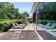 Backyard patio featuring a dining set, lounge chairs, and lush landscaping for outdoor relaxation at 8377 Se 177Th Bartram Loop, The Villages, FL 32162