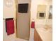 Bathroom with gold hardware, a frosted glass shower, wood vanity and towel racks at 8377 Se 177Th Bartram Loop, The Villages, FL 32162