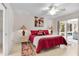 Bedroom boasts a ceiling fan, sliding glass doors to the screened porch, and neutral tile floor at 8377 Se 177Th Bartram Loop, The Villages, FL 32162