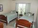 Bedroom featuring two beds, decorative pillows and view of treed outdoors at 8377 Se 177Th Bartram Loop, The Villages, FL 32162