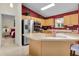 Bright kitchen features stainless appliances, light wood cabinets, island, and red accent wall at 8377 Se 177Th Bartram Loop, The Villages, FL 32162
