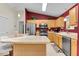 A kitchen with stainless steel appliances, light wood cabinets, and a kitchen island at 8377 Se 177Th Bartram Loop, The Villages, FL 32162