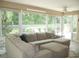 Inviting living room with a large sectional sofa, offering scenic views of the lush backyard at 8377 Se 177Th Bartram Loop, The Villages, FL 32162