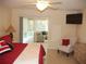 The main bedroom has a ceiling fan, an exit to the lanai, a television and a sitting chair at 8377 Se 177Th Bartram Loop, The Villages, FL 32162