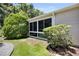 A screened porch/sunroom surrounded by green lush landscaping for backyard privacy at 8377 Se 177Th Bartram Loop, The Villages, FL 32162